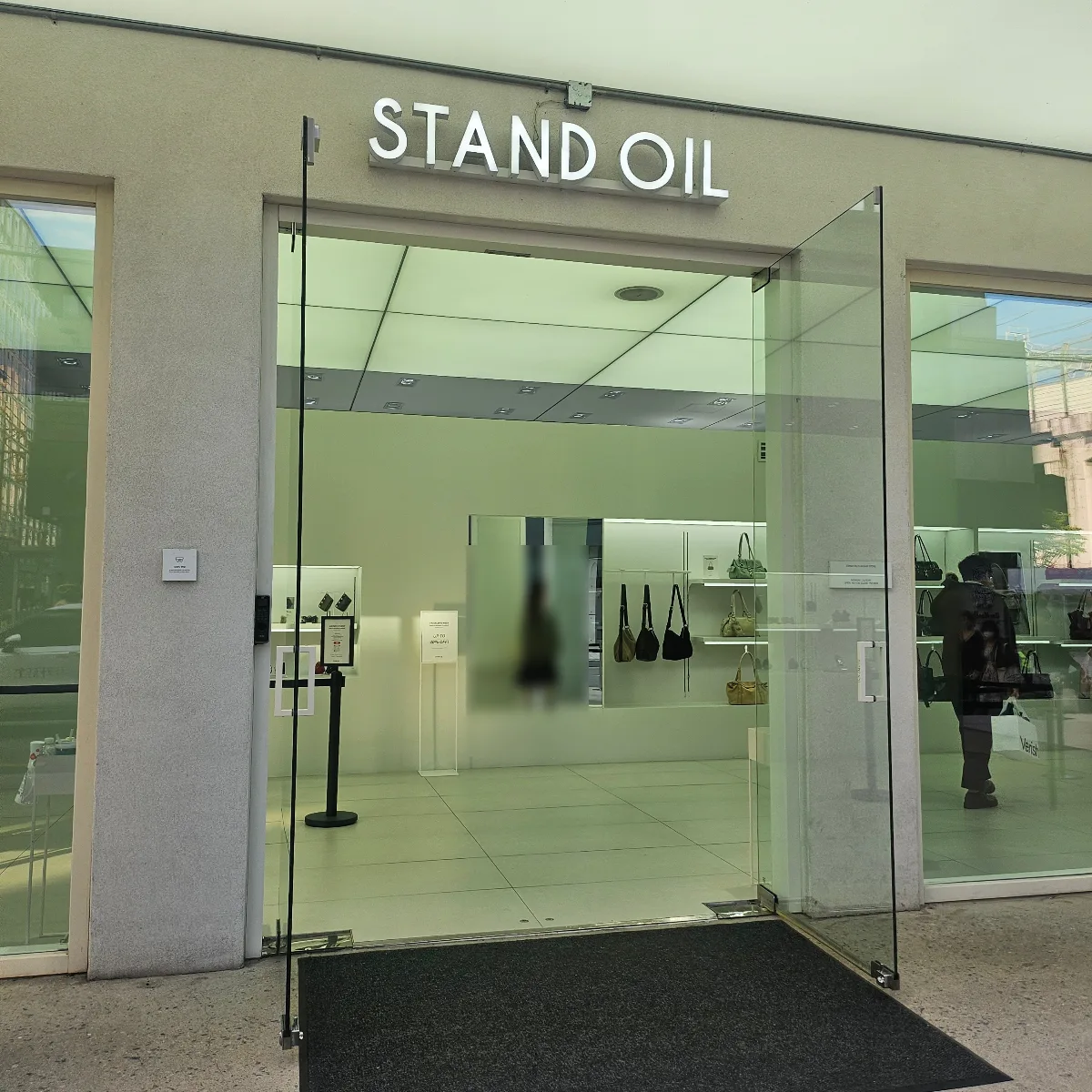 STAND OIL 聖水店 — STAND OILの看板とガラス扉
