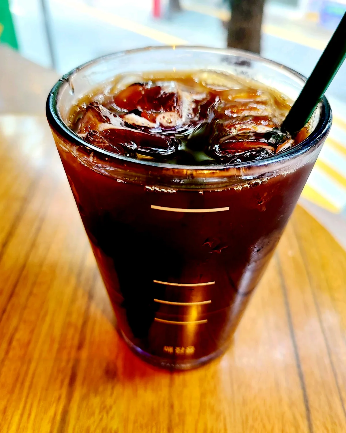 氷入りコーヒーと黒いストロー