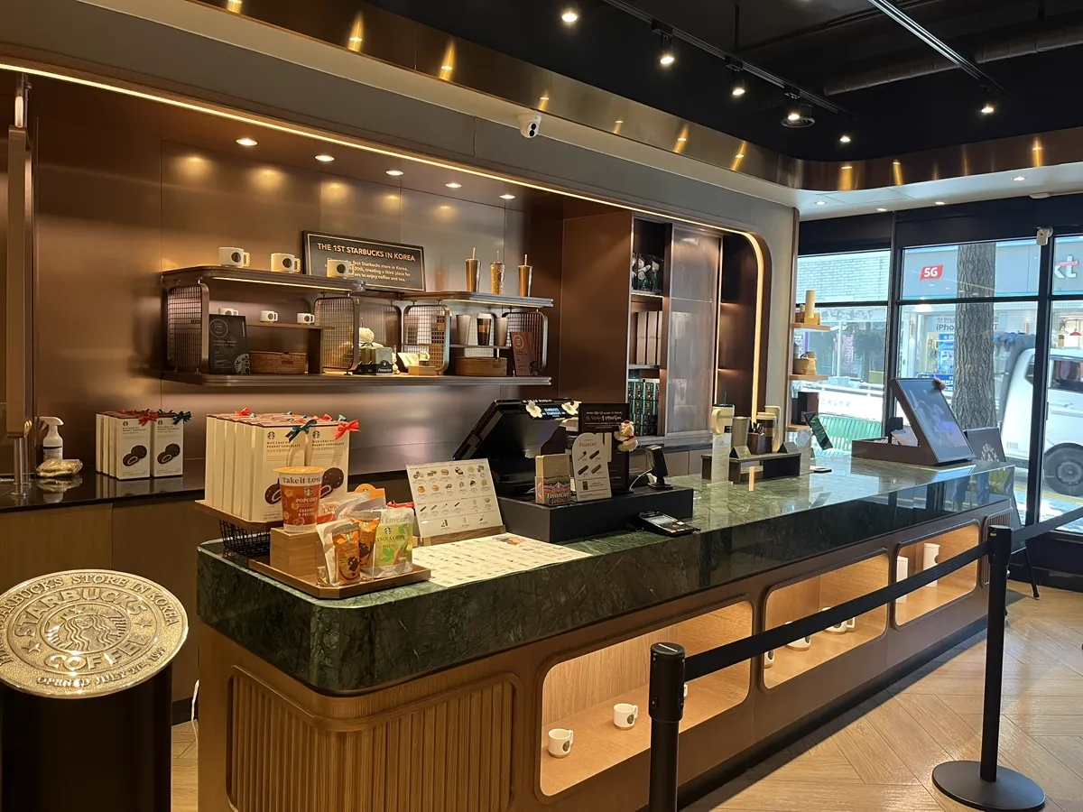 スターバックス 梨大店 — 1号店の記念棚とレジカウンター