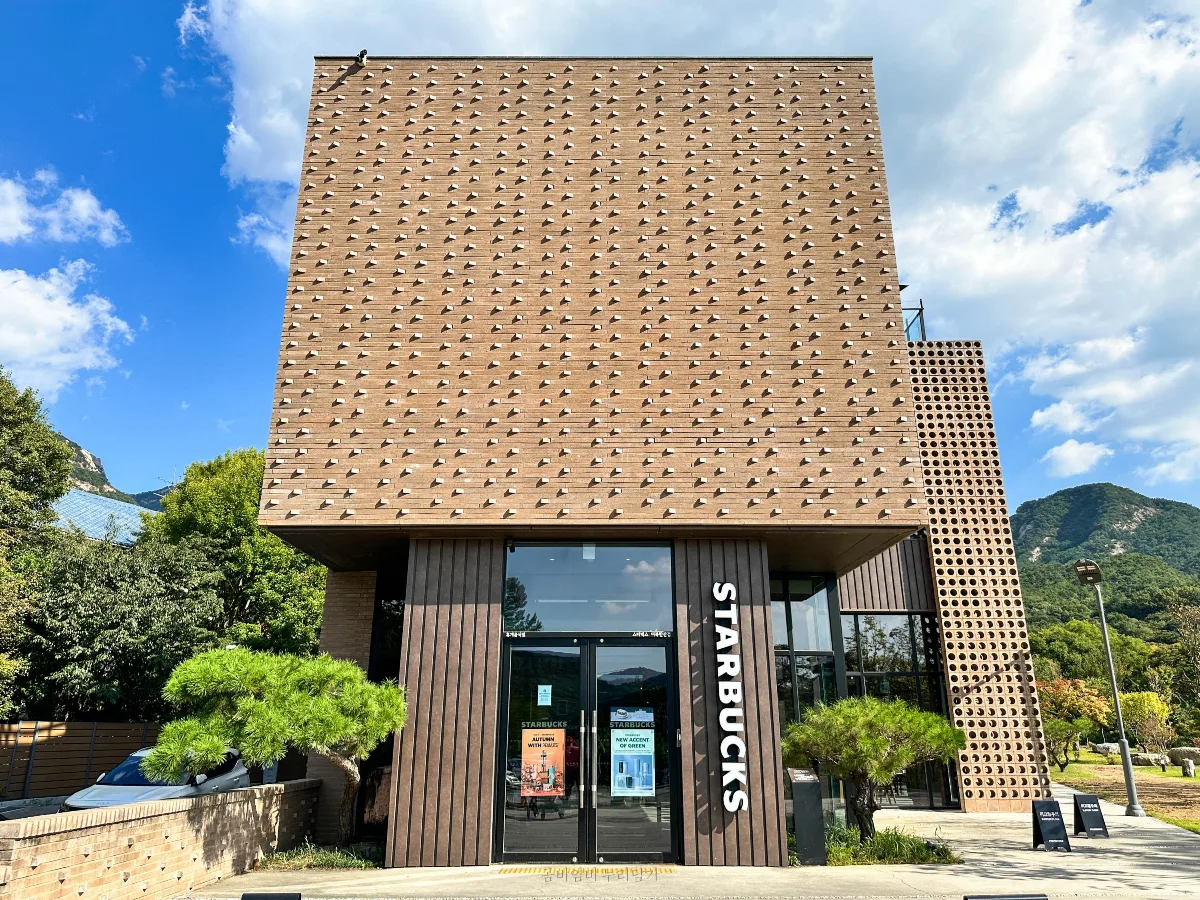 スターバックス ザ北漢山店 — レンガの壁とスターバックスの入口