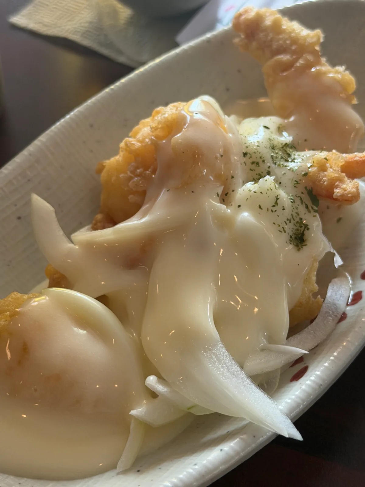 玉ねぎとクリームソースをかけたエビの揚げ物