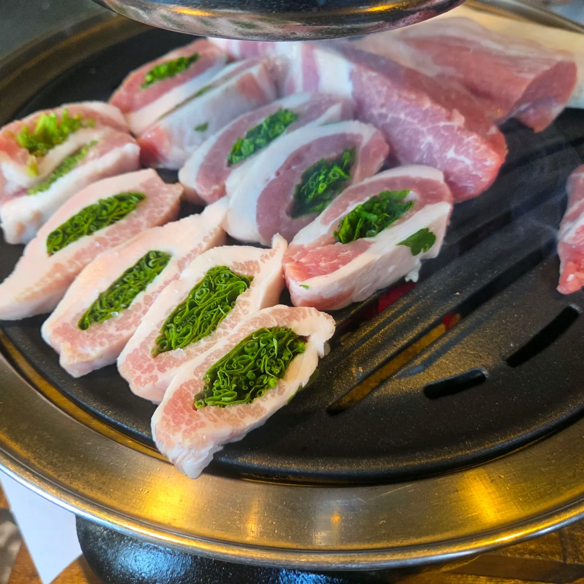 ソリャミョッ 西面店 — 網の上に並ぶミナリ入りの豚肉