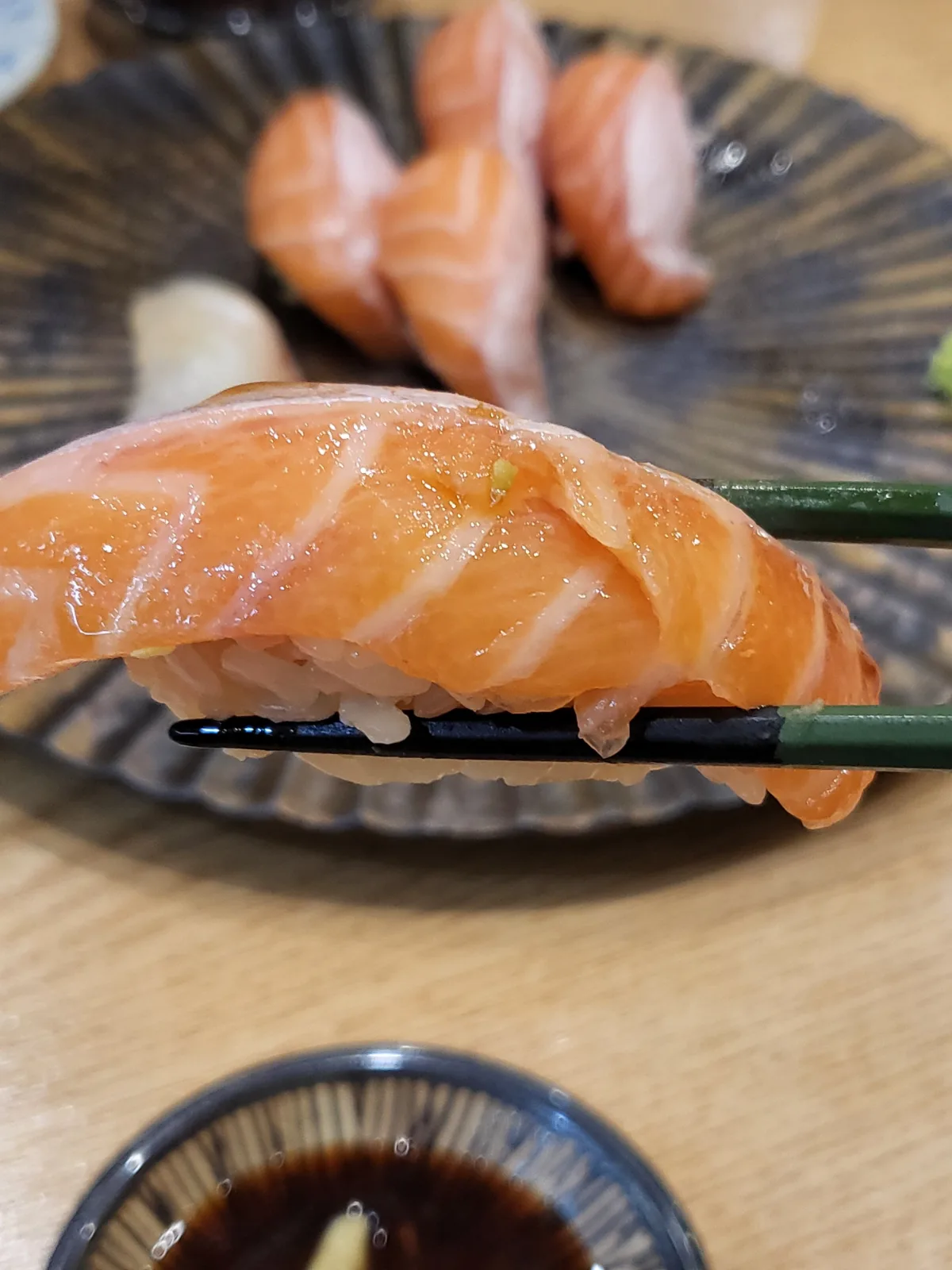 スシ・ジヒョン — 箸で持ち上げたサーモン寿司