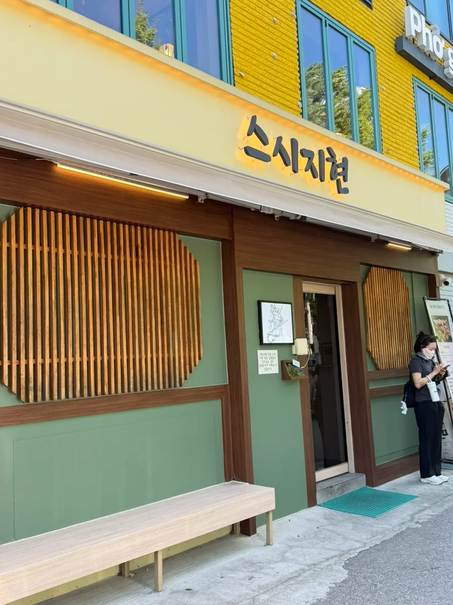 スシ・ジヒョン — スシ・ジヒョンの店先と木のベンチ