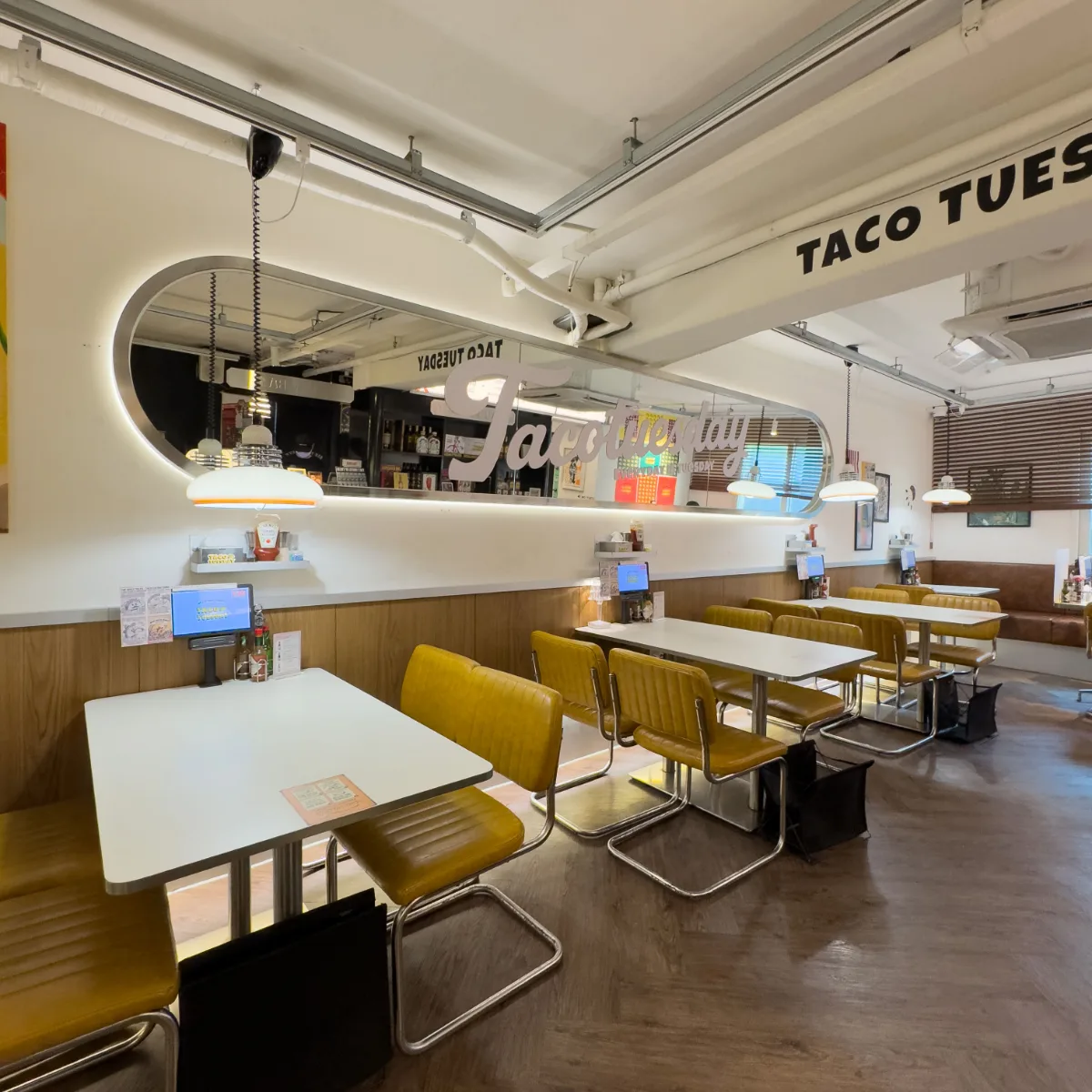 TACO TUESDAY 聖水本店 — 黄色い椅子が並ぶテーブル席