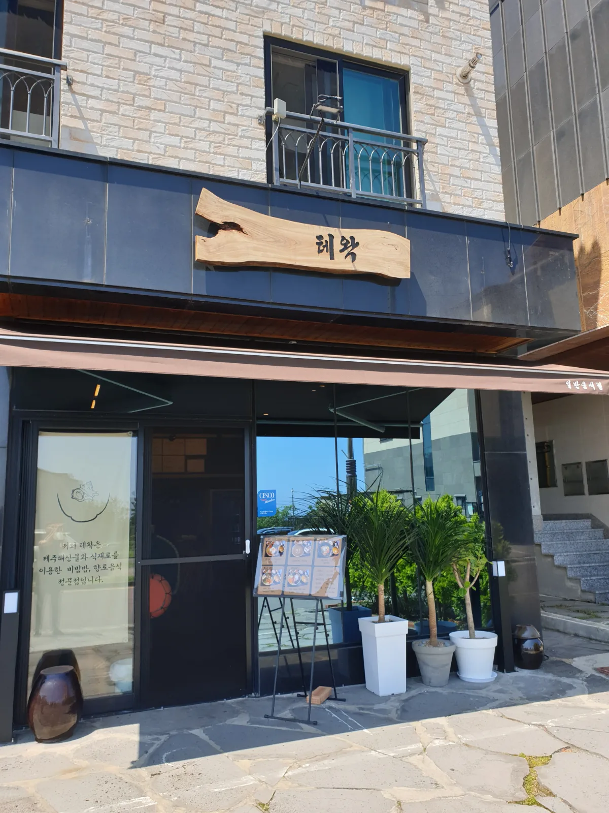 テワク — 木の看板を掲げた店先