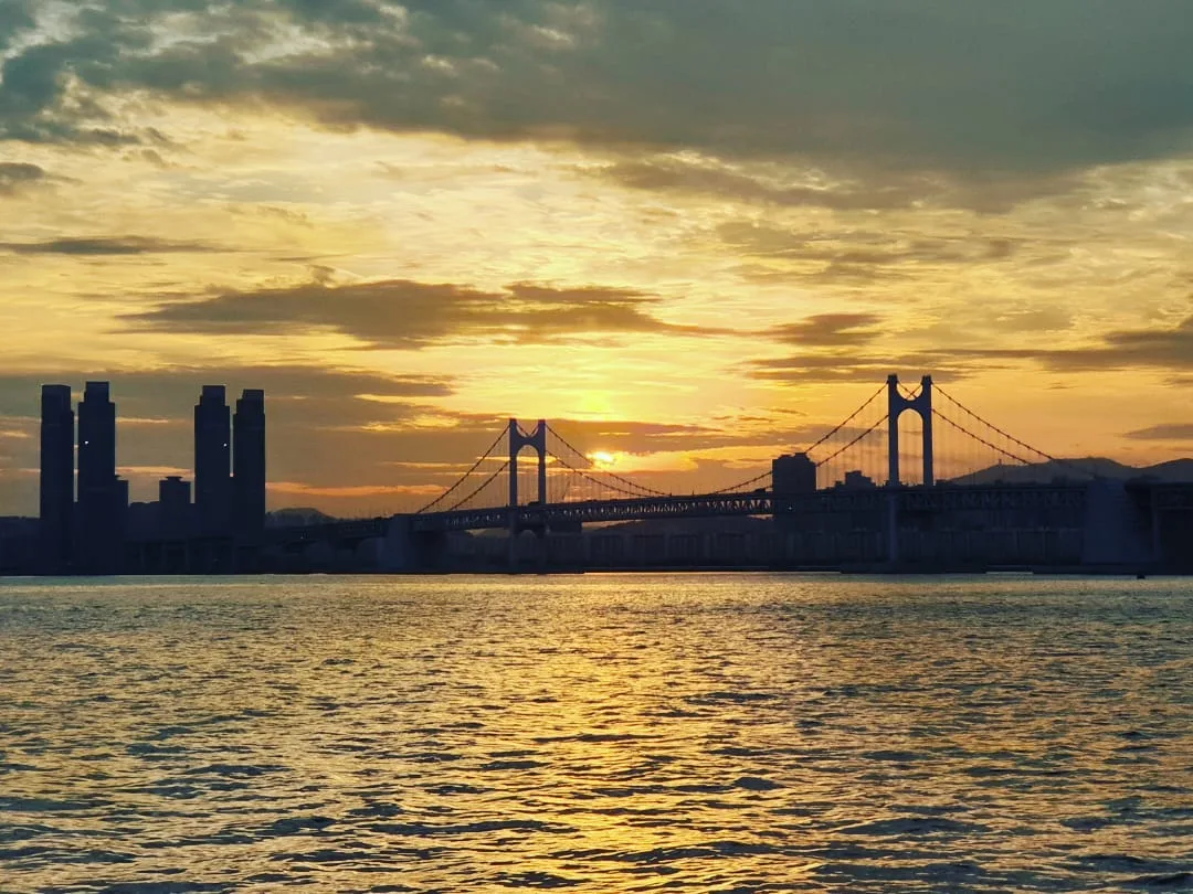 夕日に染まる海と広安大橋のシルエット