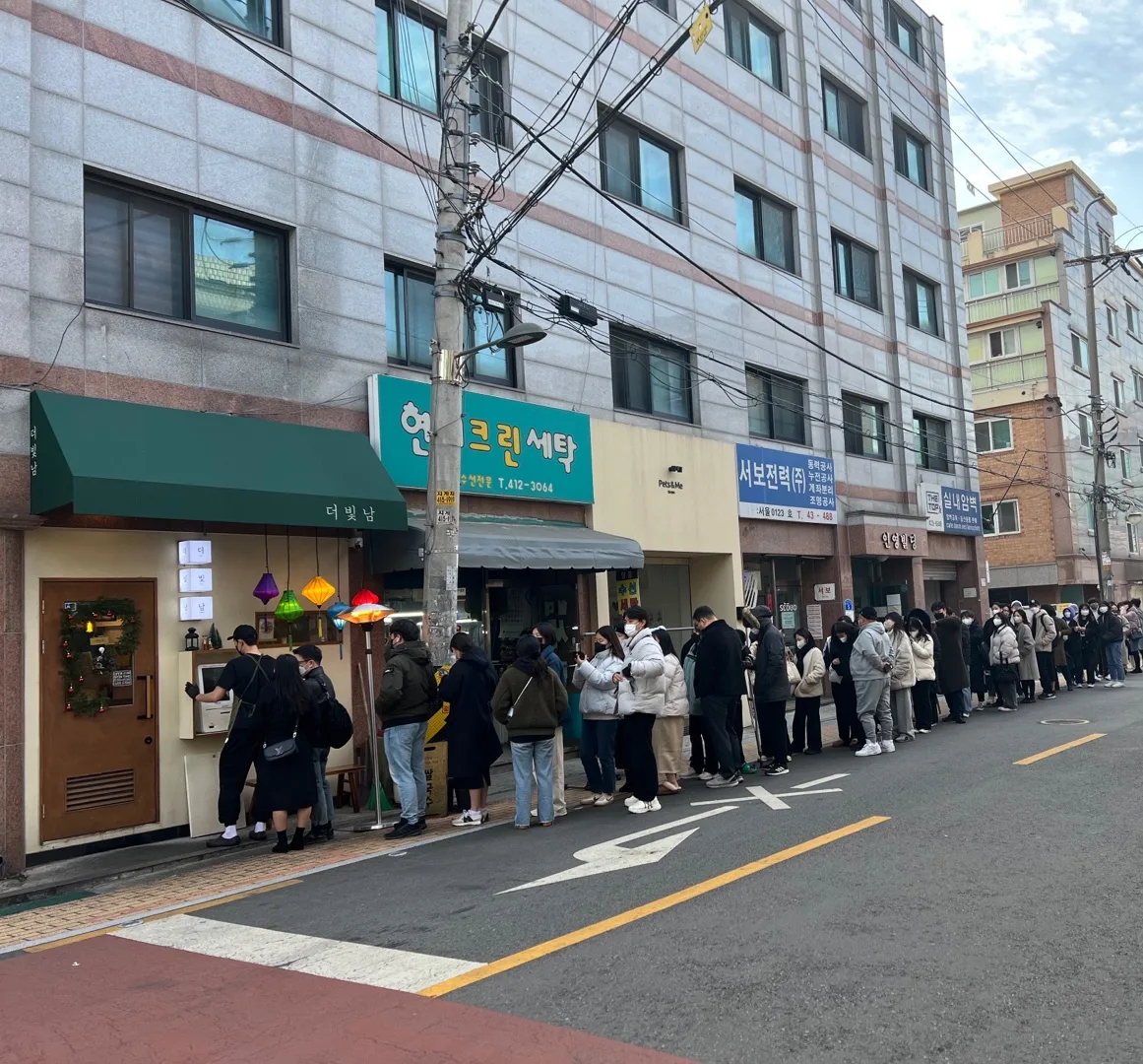 緑のひさしの前に続く行列