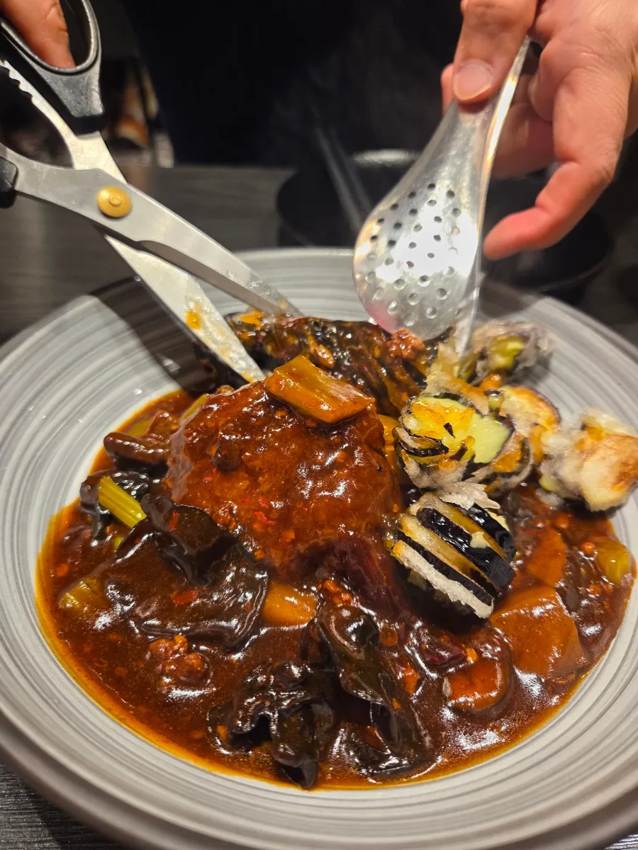 濃い色のソースをまとった肉団子とナス