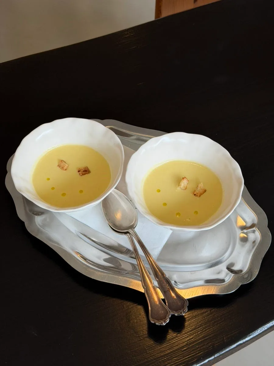 銀のトレーにのった黄色いスープ