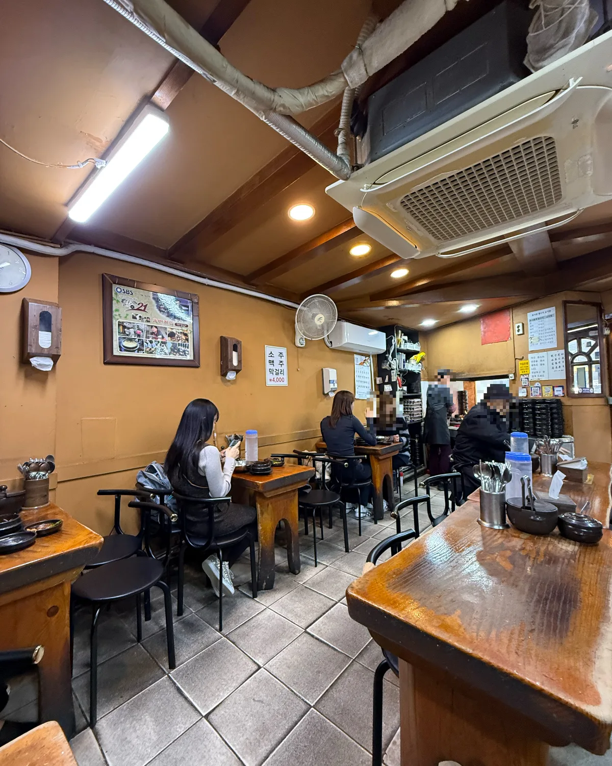 トゥッペギチッ — 木のテーブルと黒い椅子が並ぶ店内