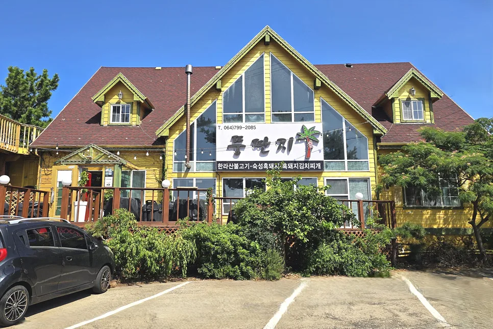 トゥンタンジ 涯月黒豚 本店 — 三角屋根と黄色い壁のトゥンタンジ