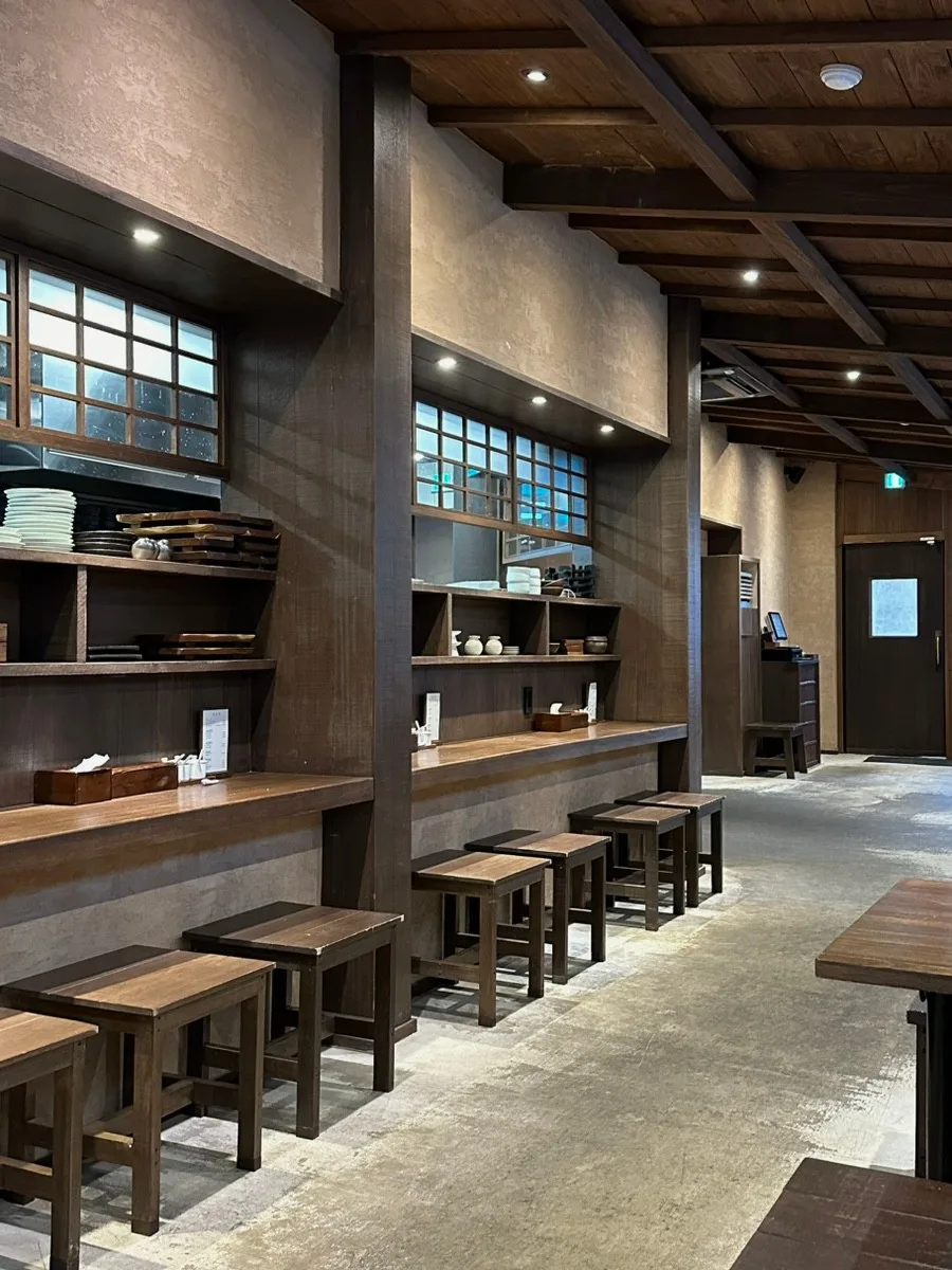 オムヨンベク・テジクッパ 海雲台店 — 木のカウンターと一人用の椅子