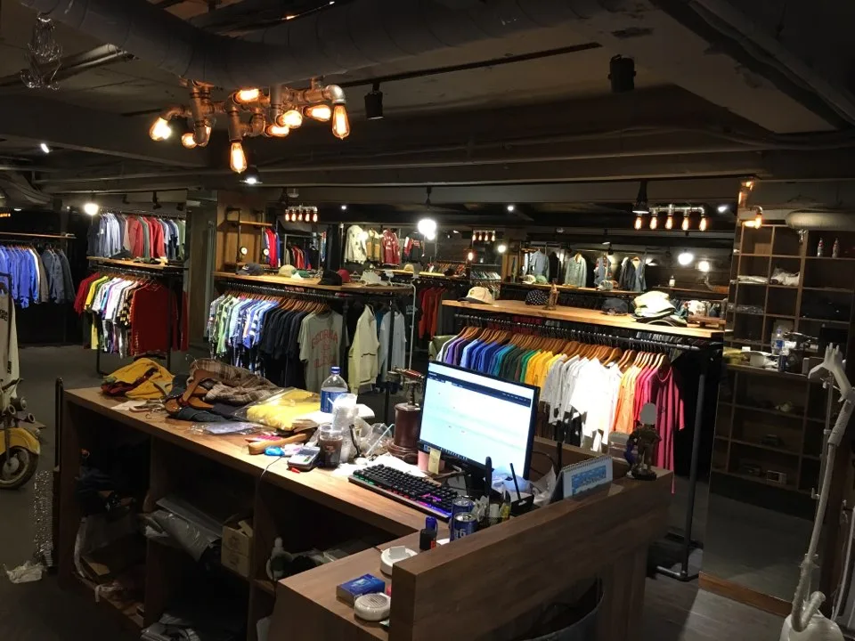 木製カウンターと色とりどりの古着