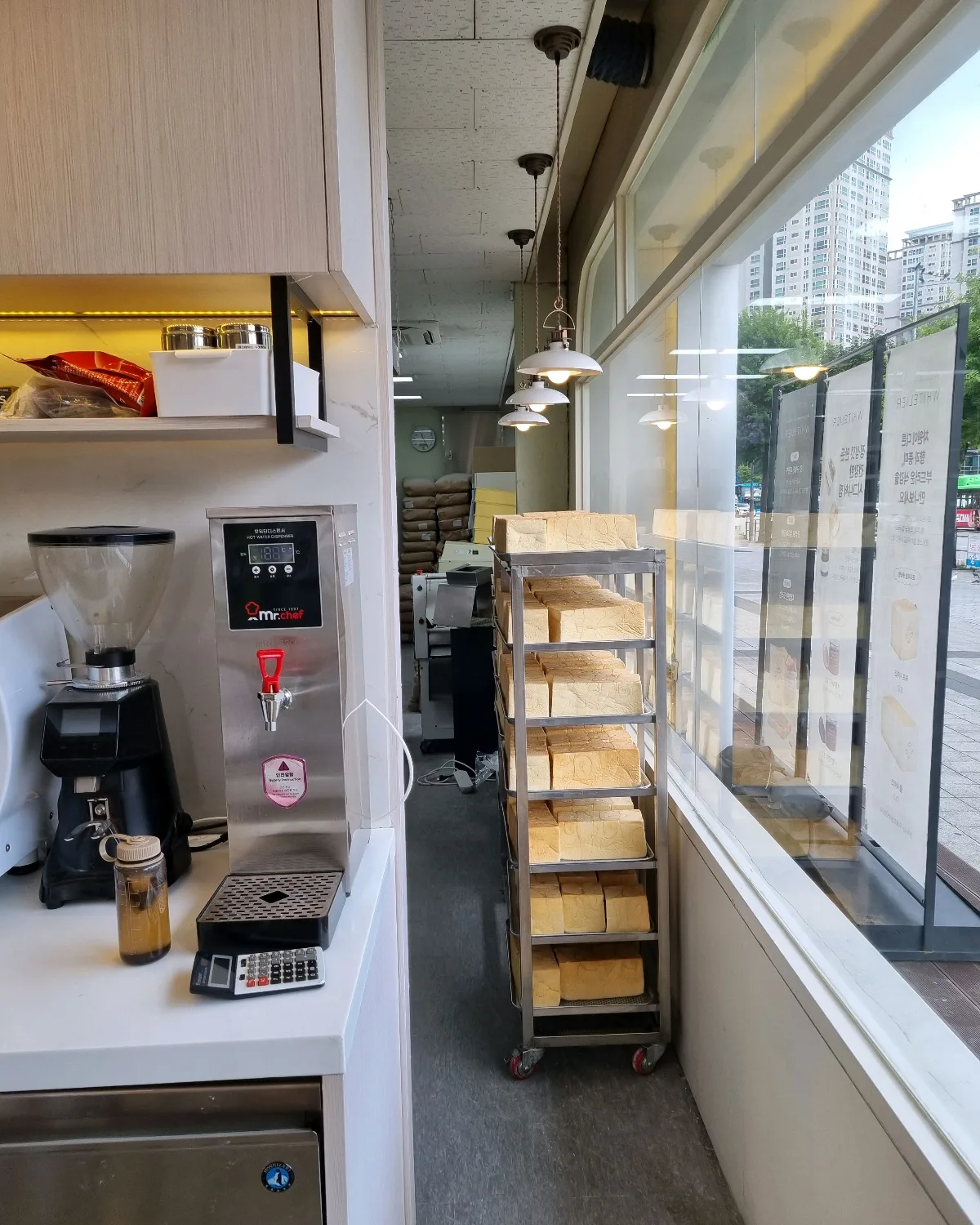ホワイトリエ 盤浦本店 — 窓沿いに並ぶ食パンのラック