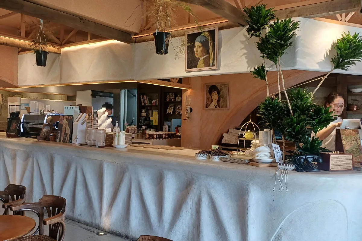 植物と絵画を飾ったカフェカウンター