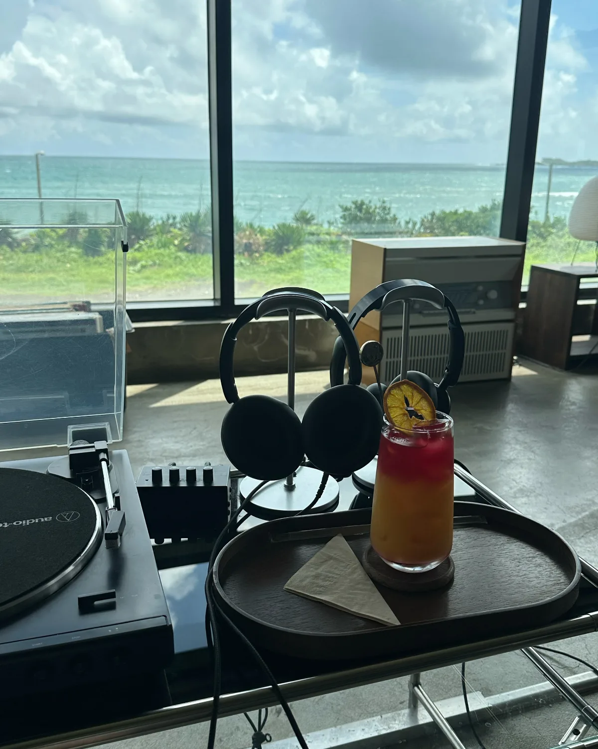 海を背にしたヘッドホンとドリンク