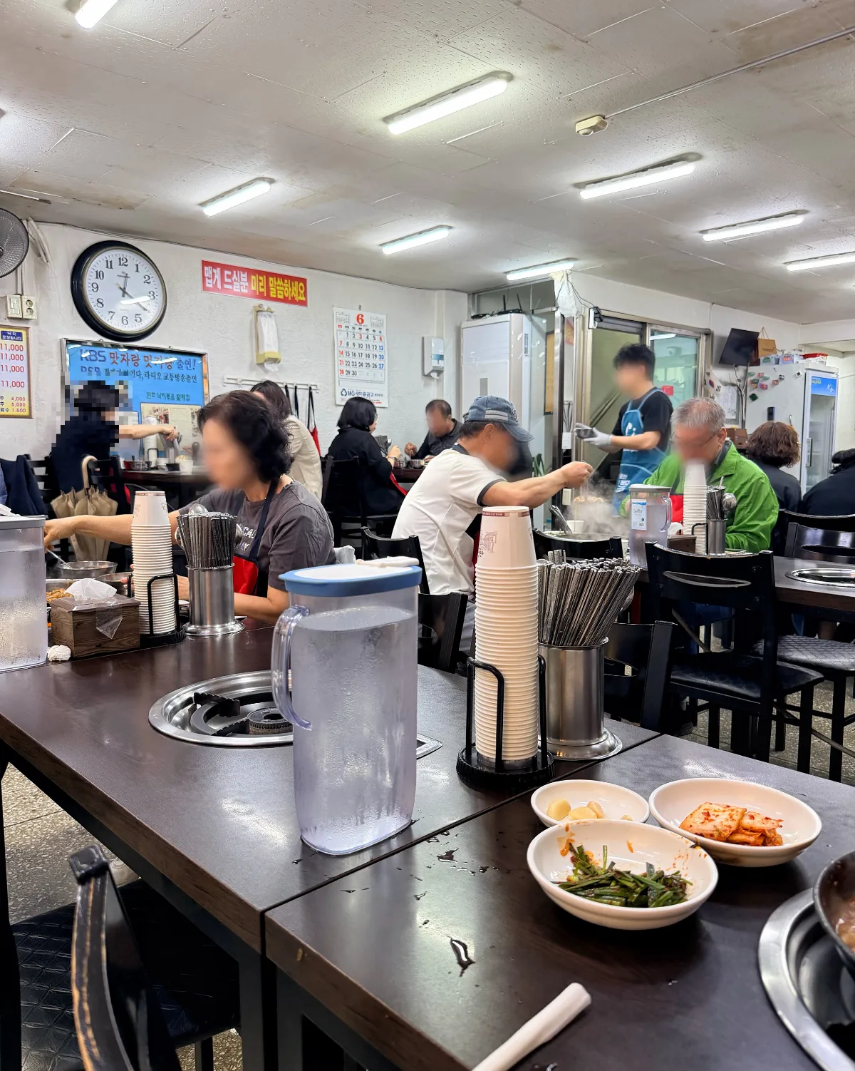 客が卓を囲む食堂の店内