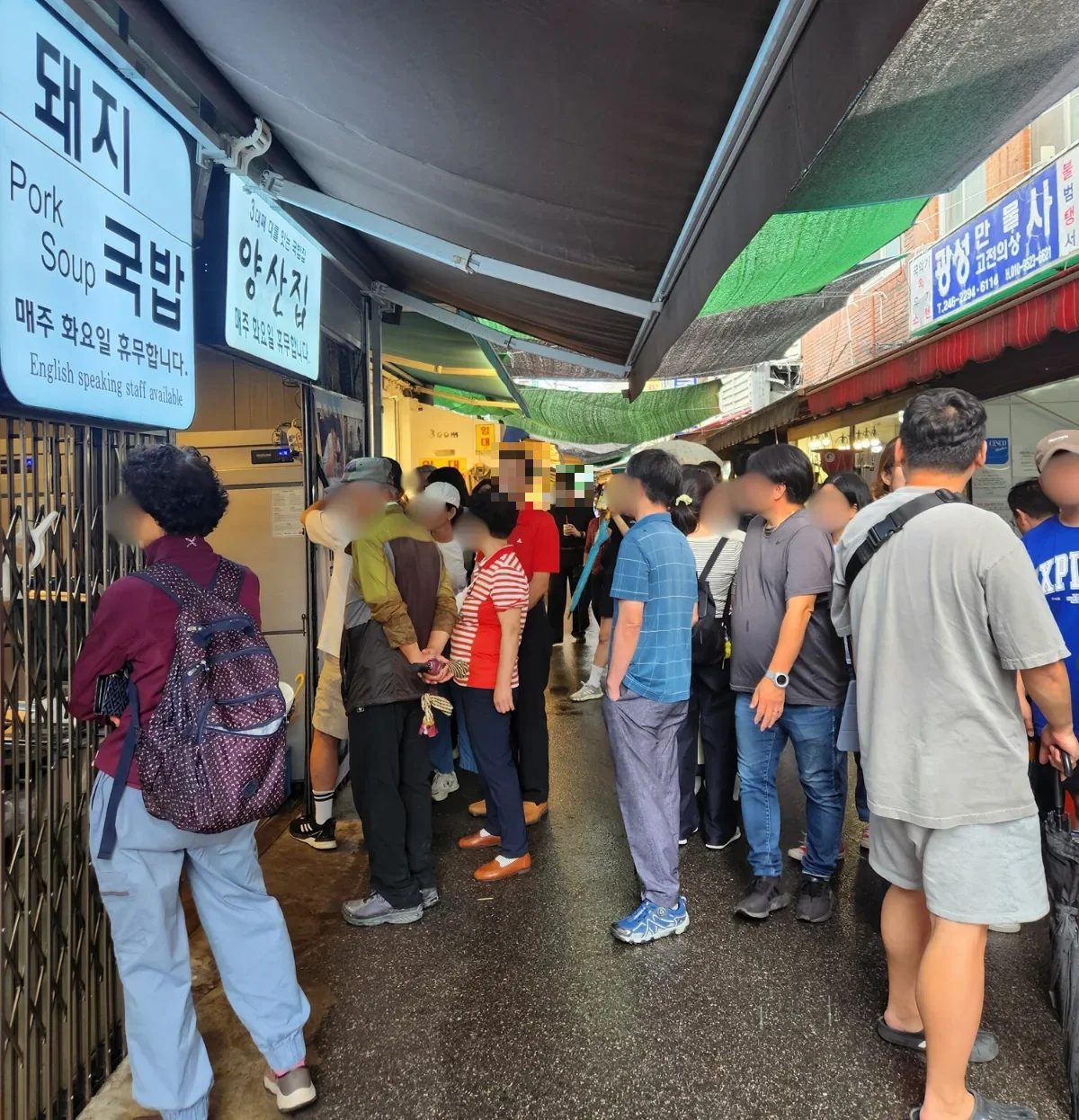 市場の通路で店の前に並ぶ人々