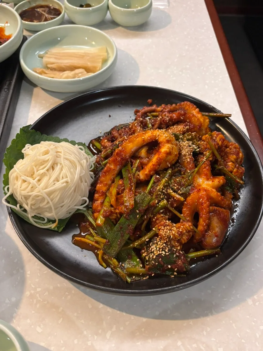 細麺を添えた生テナガダコの辛炒め