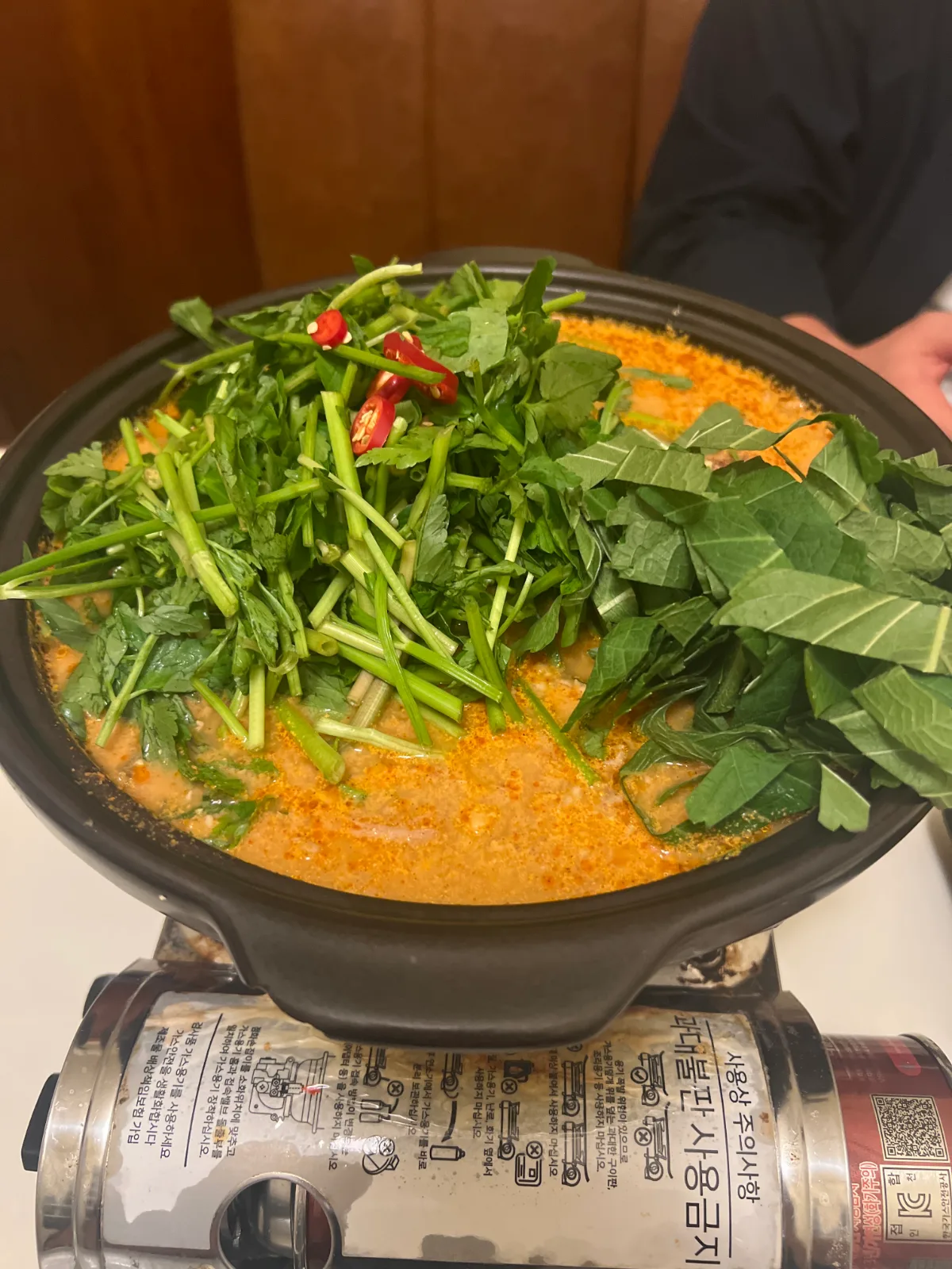 青菜をのせた赤い鍋