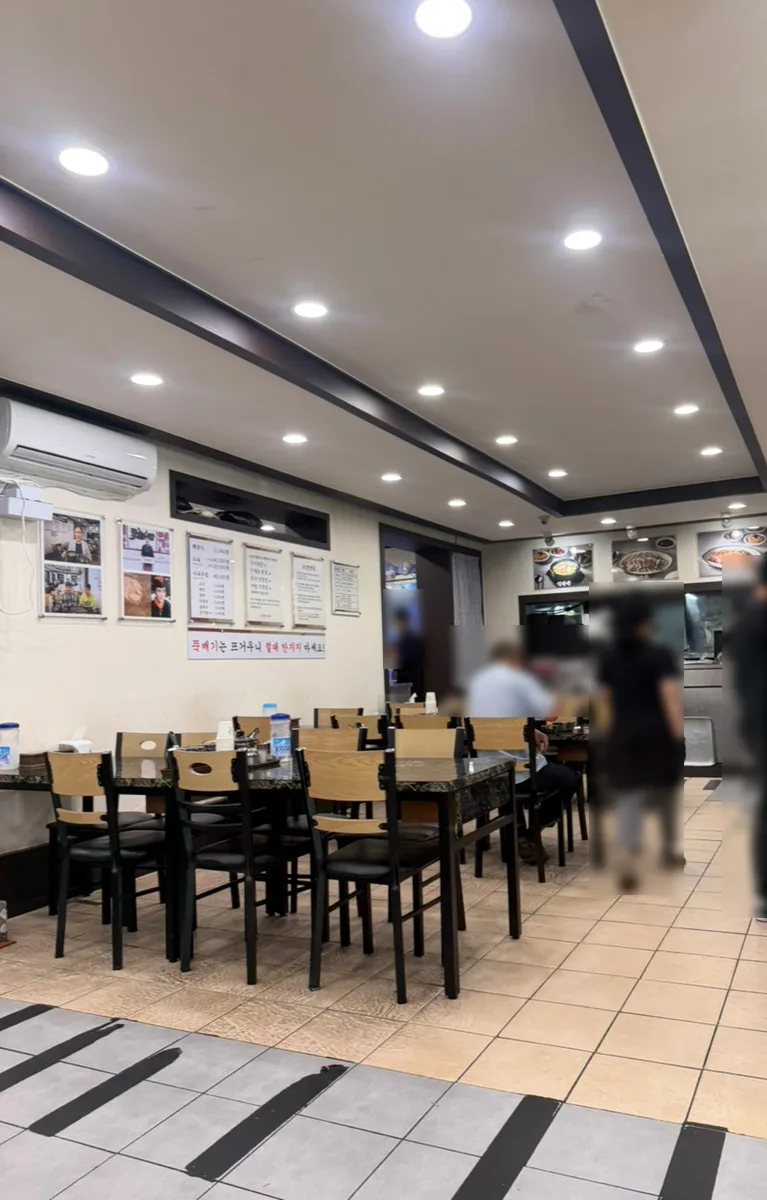 ユチ会館 本店 — 木の椅子とテーブルが並ぶ店内