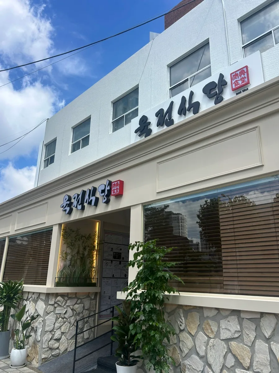 肉典食堂 本店 — 肉典食堂の看板がある白い建物