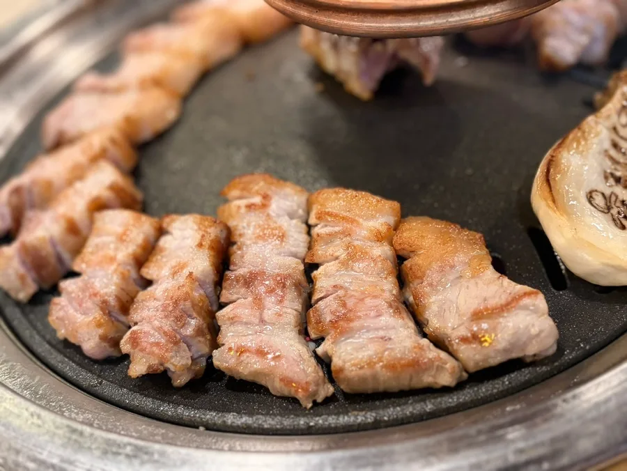 肉典食堂 本店 — 鉄板で焼く厚切りの豚バラ肉
