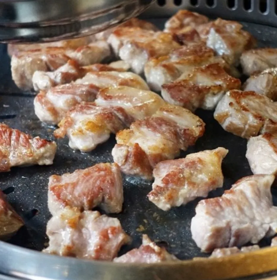肉典食堂 本店 — 一口大に切って焼かれる豚肉