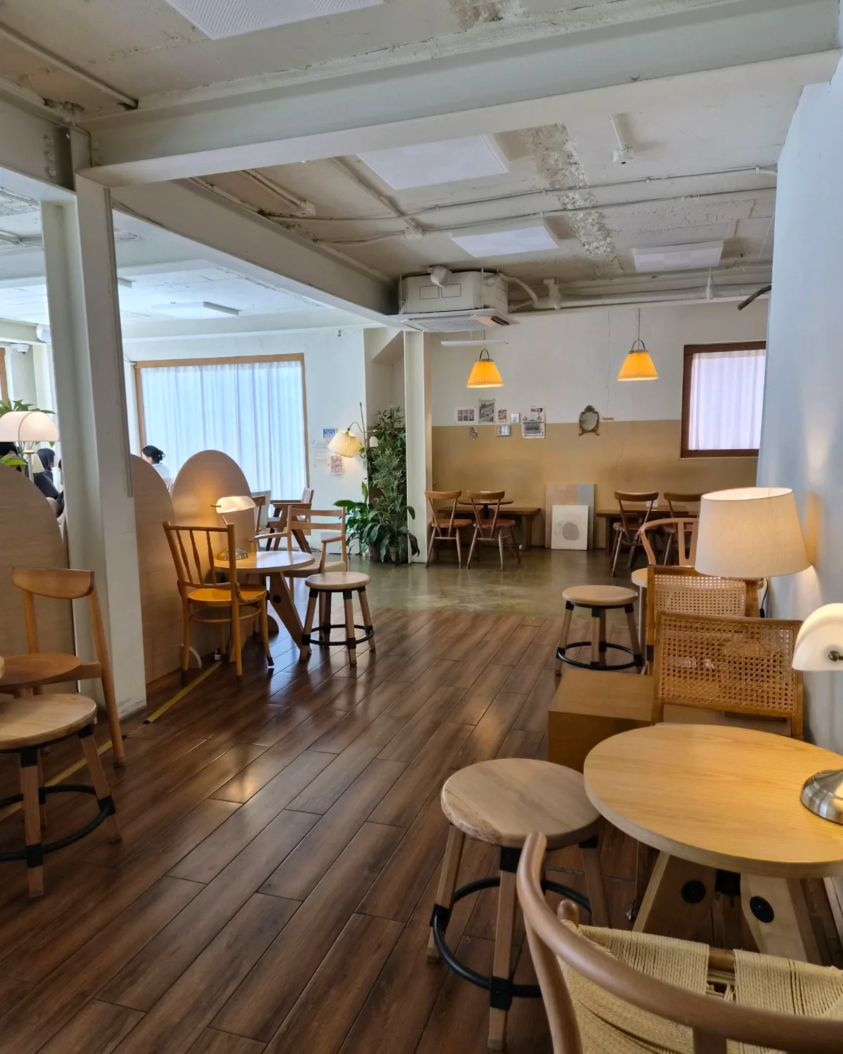 zakdangmoi 延南店 — 木の床と丸いテーブルが並ぶ店内