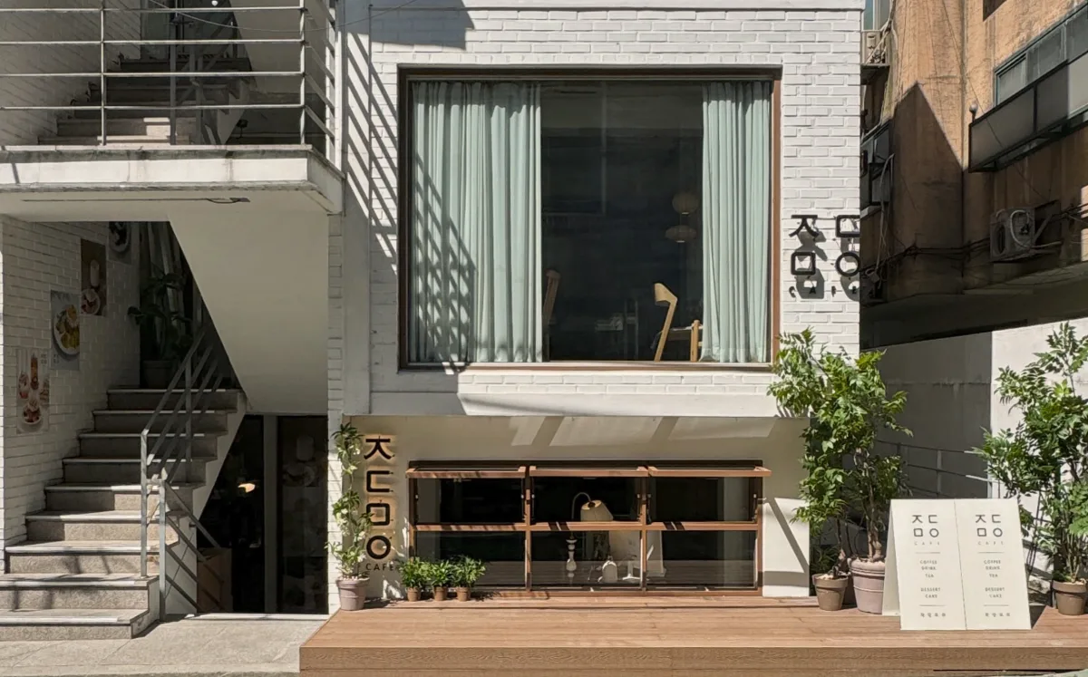 白いレンガの建物とウッドデッキの入口