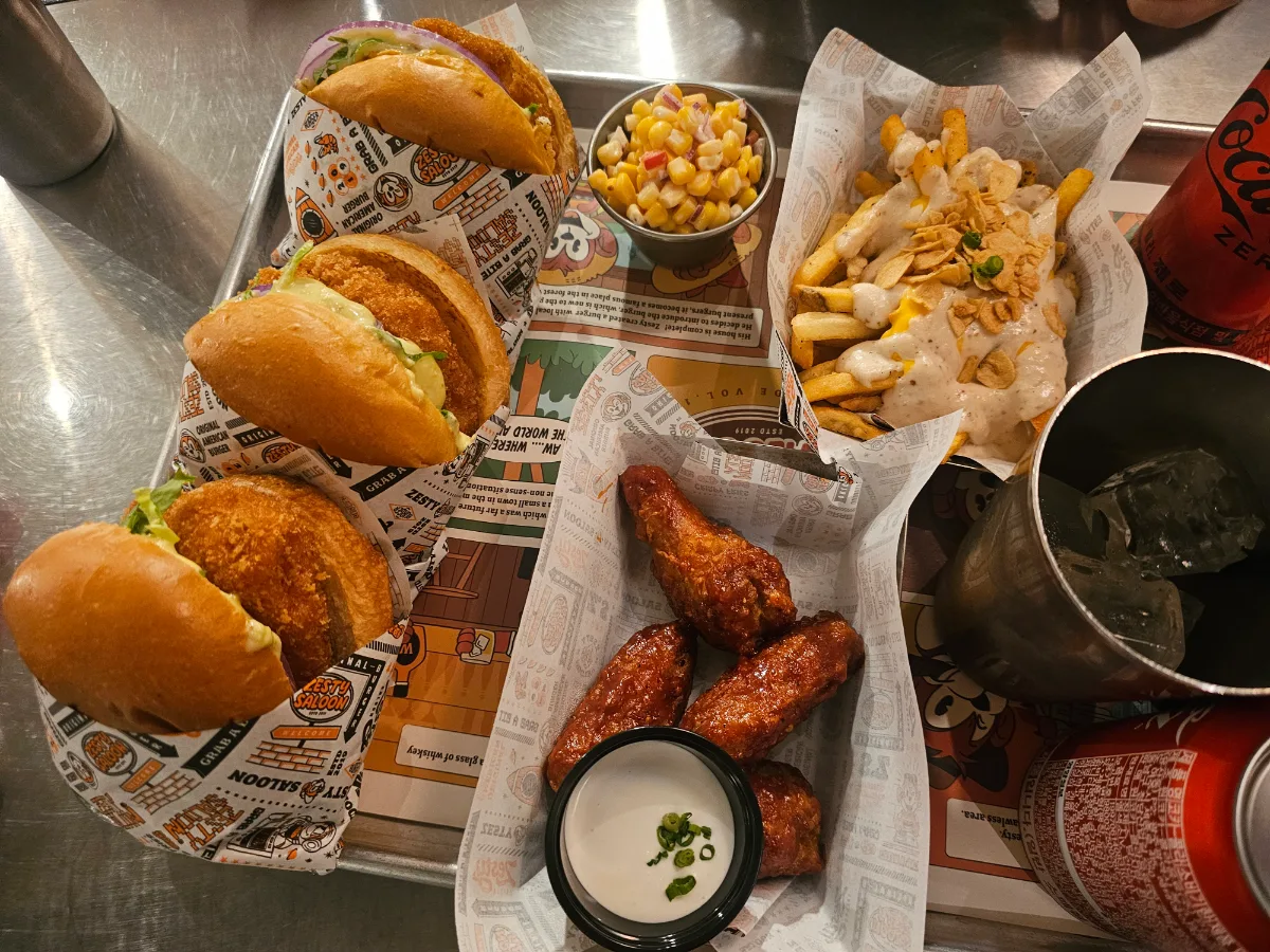 ZESTY SALOON 聖水店 — バーガーと手羽先が並ぶトレー
