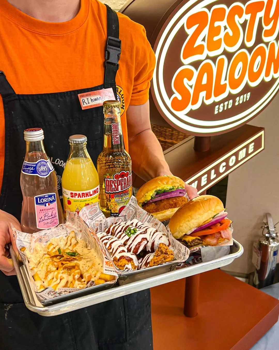 ZESTY SALOON 聖水店 — バーガーとポテト、瓶ドリンクをのせたトレー